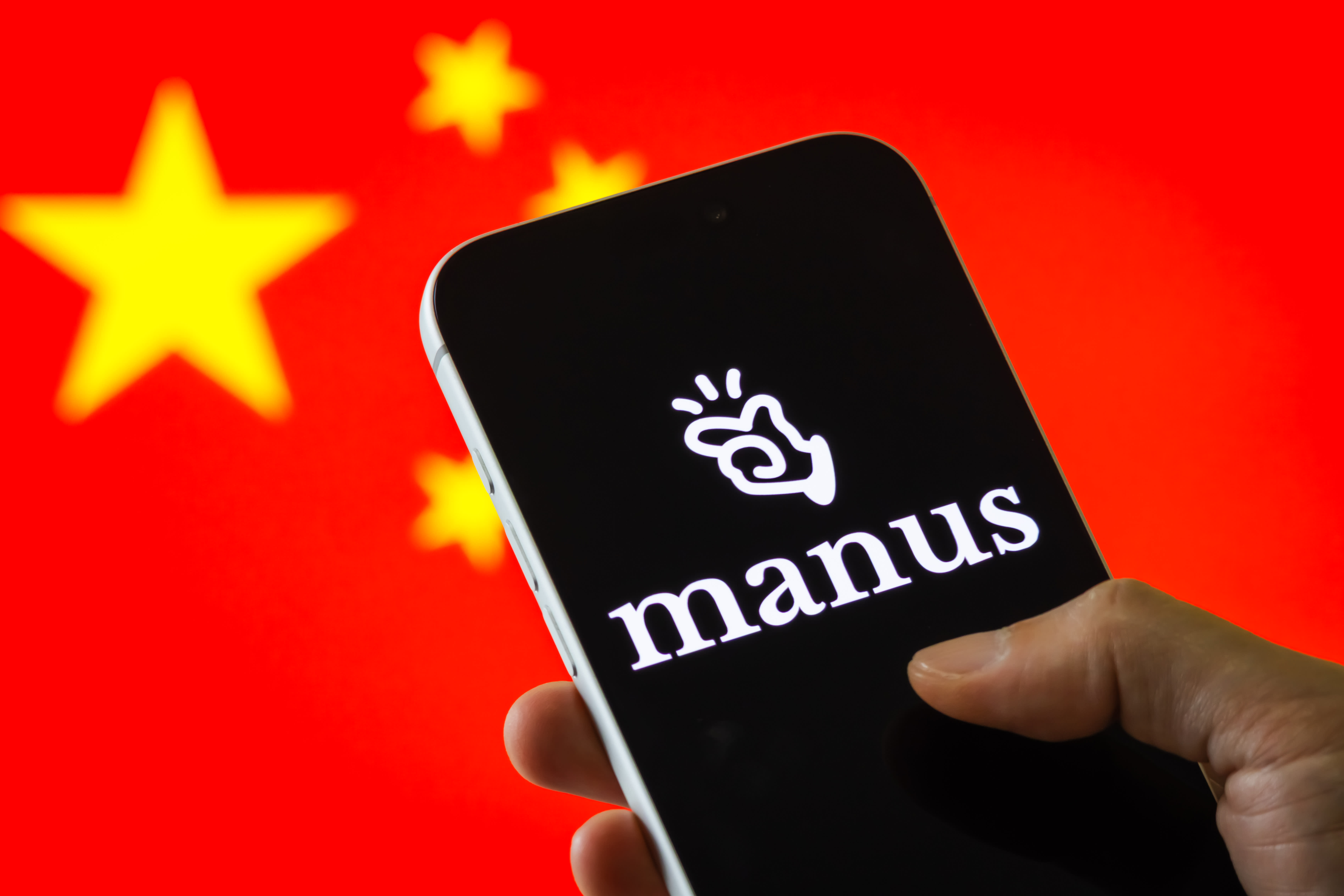 CHONGQING, CHINA - JANUARY 07: In this photo illustration, the Manus logo is displayed on a smartphone screen, with the Chinese national flag visible in the background, on January 7, 2026 in Chongqing, China.